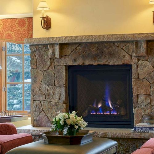 Cozy living room with a stone fireplace and a warm glow, perfect for relaxing by the fire tonight.